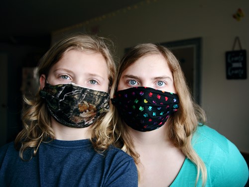 Two young women wearing fabric face masks