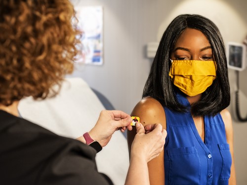 Woman getting a plaster over her vaccine shot