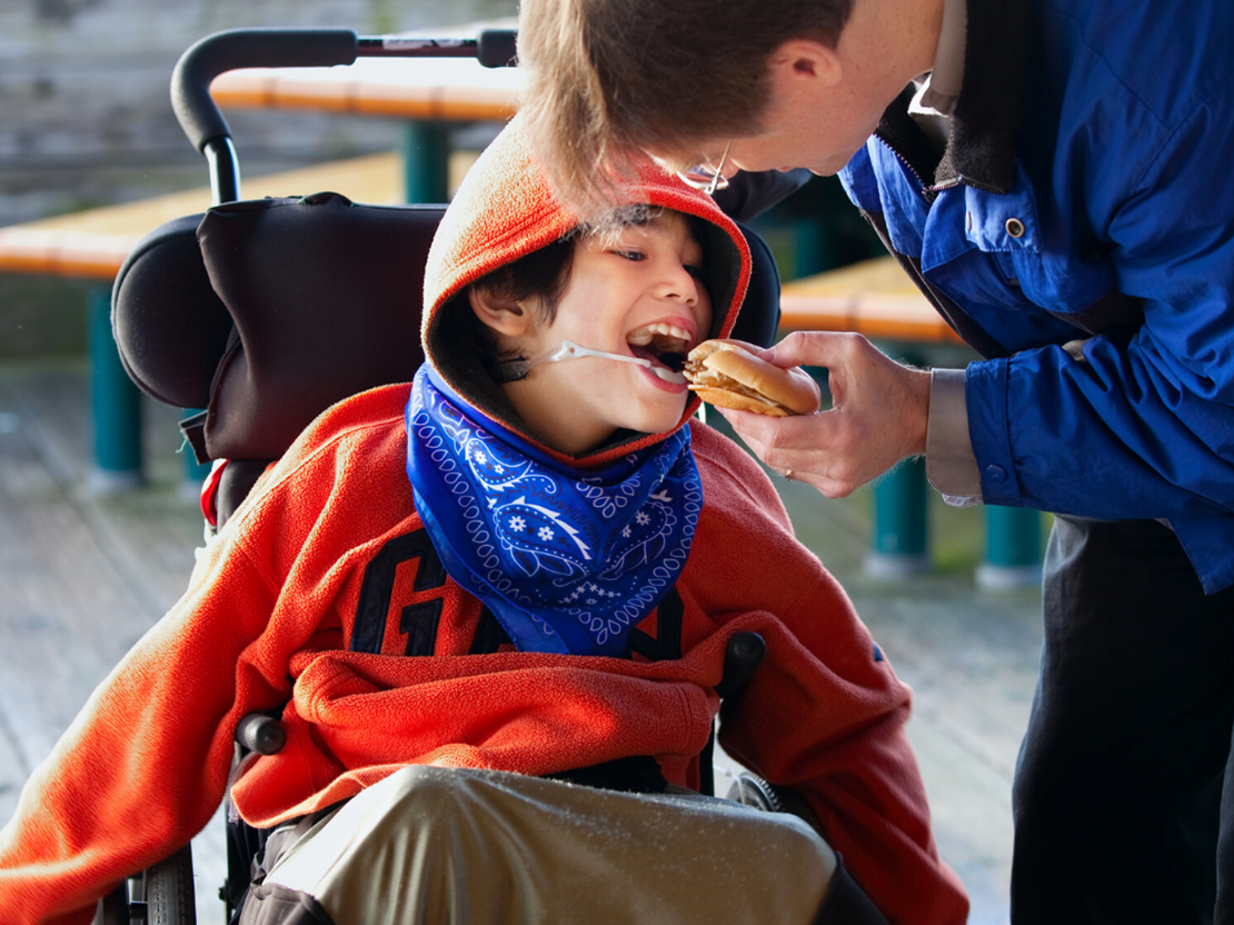 A person helping a child eat food