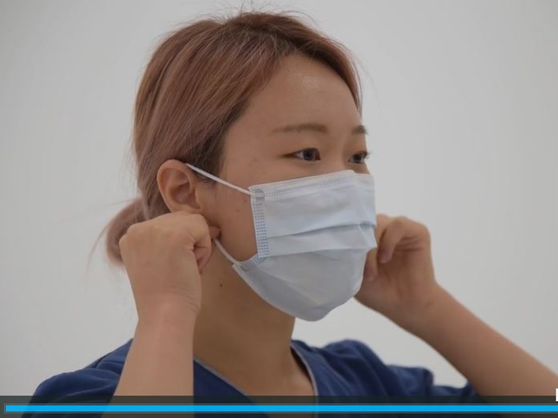 Woman putting on surgical mask