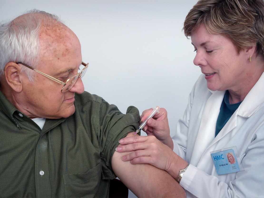 Elderly man getting an injection on left arm.jpg