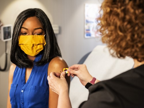 Woman getting a plaster over her vaccine shot_reverse.jpg